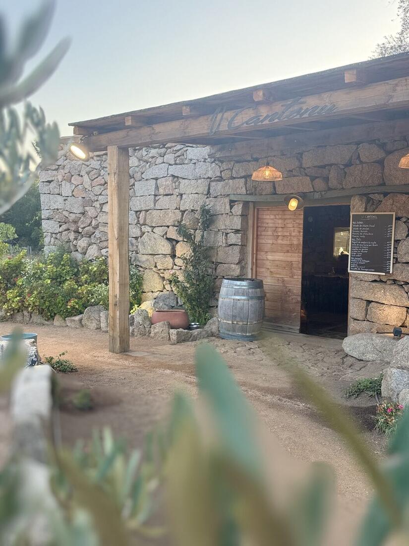 La façade en pierre de la bergerie, avec l'enseigne U Cantonu et l'ardoise du menu