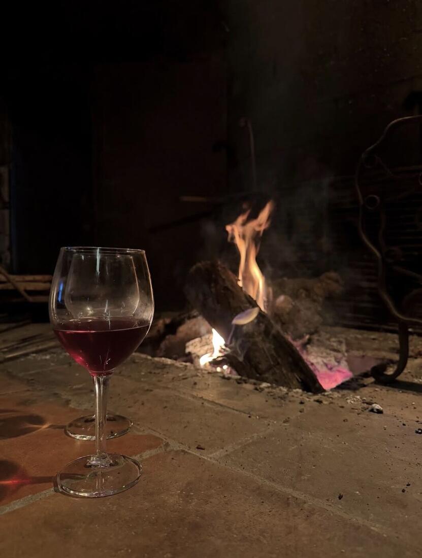 Un verre de vin rouge près du feu de bois