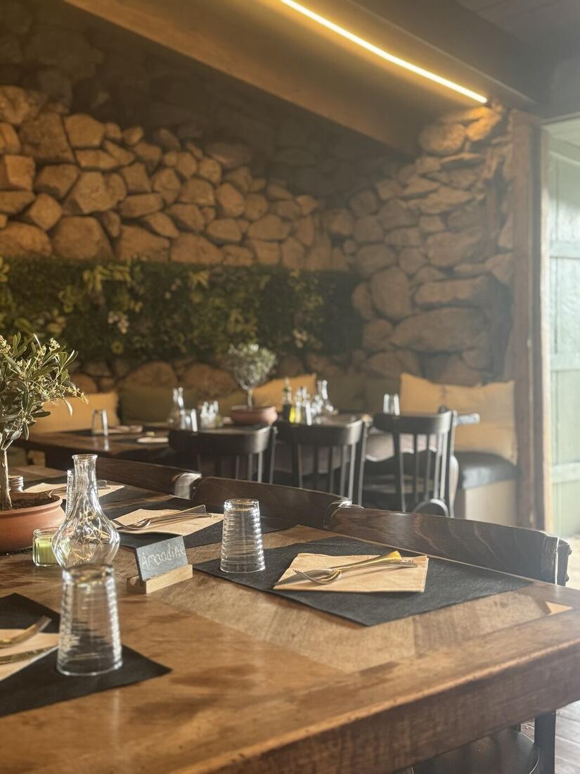 Une table dressée devant le mur de pierre et le mur végétal